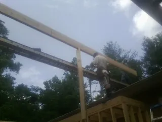 Carpenter setting a ridge beam over a new addition frame — Ice Dam Removal by Roofing Brothers in Greenbrae