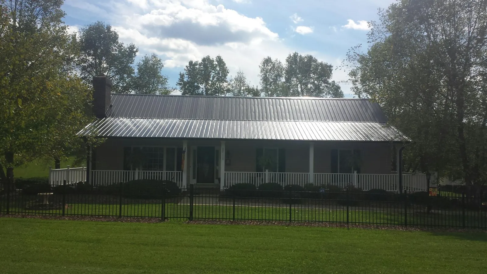 Gray metal roof on a brick ranch with a full width front porch — Gutter Guard Installation work by our crew in Greenbrae